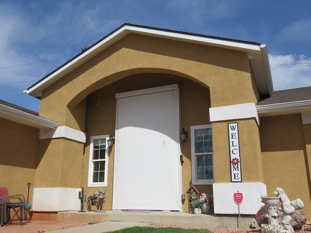 doorway to property featuring stucco siding