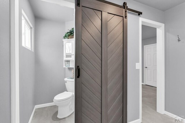 bathroom with baseboards and toilet