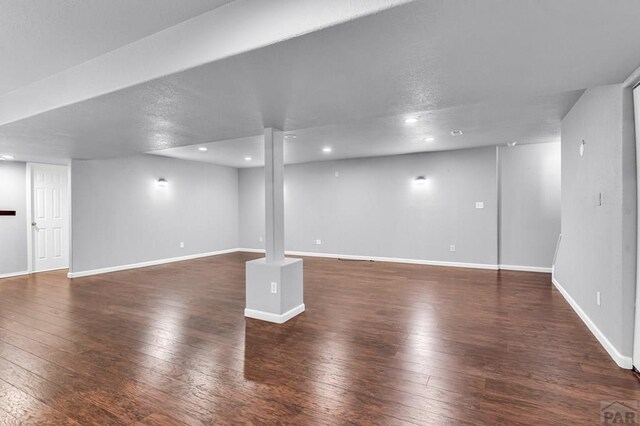 finished basement with dark wood-style floors, recessed lighting, and baseboards