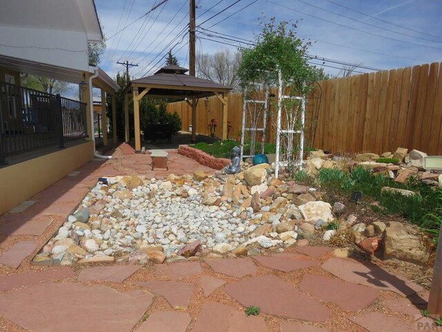 view of yard featuring fence, a patio, and a gazebo