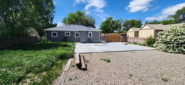 rear view of property with a yard, a patio area, and a fenced backyard