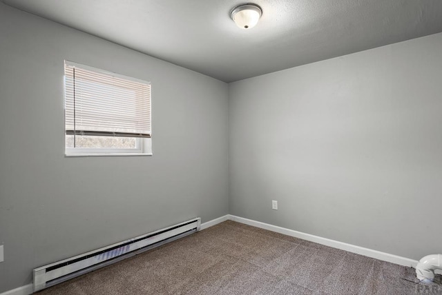 spare room with a baseboard heating unit, carpet floors, and baseboards