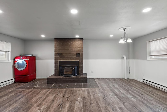 unfurnished living room featuring a wainscoted wall, baseboard heating, wood finished floors, and recessed lighting