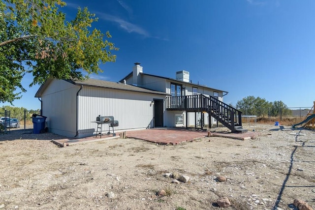 back of house featuring a trampoline, stairway, and a patio