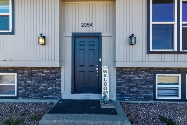 doorway to property featuring stone siding