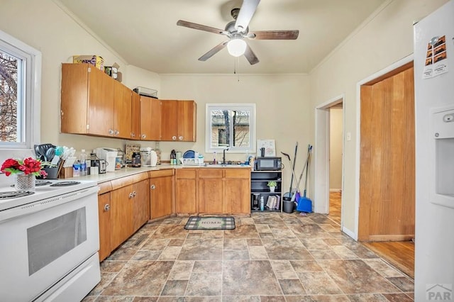 kitchen with brown cabinetry, white range with electric stovetop, light countertops, and a sink