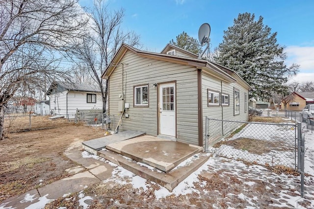 snow covered house featuring fence