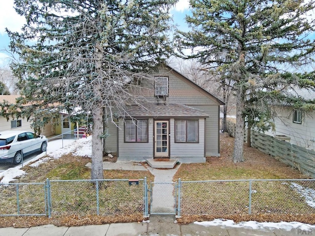 bungalow featuring a shingled roof, a fenced front yard, and a gate