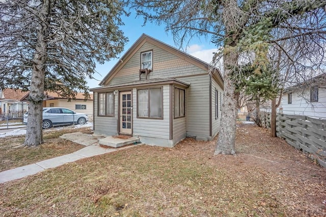 view of front of property featuring fence and a front lawn