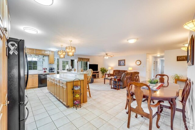 kitchen with a breakfast bar area, a kitchen island, open floor plan, light countertops, and black appliances