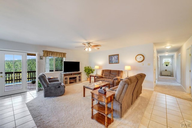 living room with light tile patterned floors, a ceiling fan, and baseboards