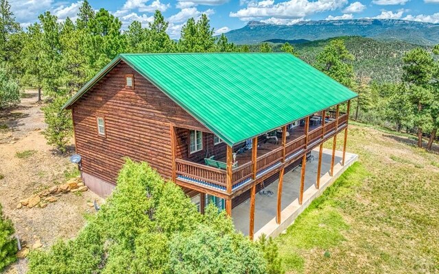 exterior space with a yard, metal roof, and a deck with mountain view