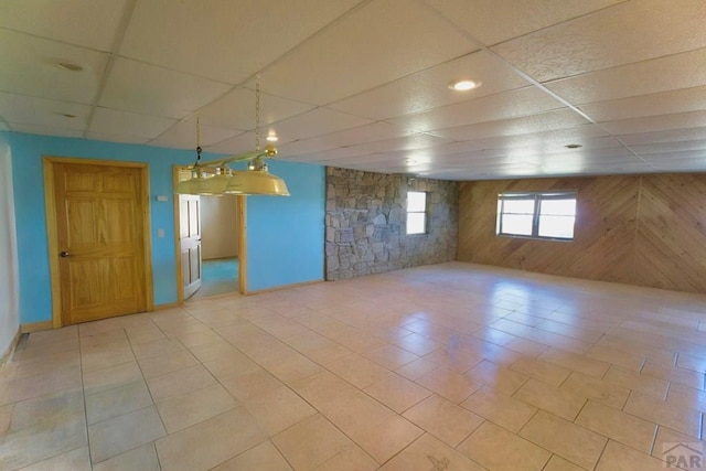 below grade area with wooden walls and a paneled ceiling