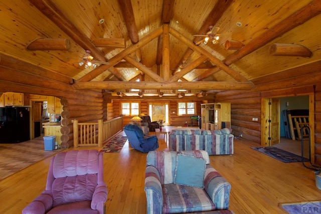 living area with ceiling fan, beam ceiling, wooden ceiling, light wood-style floors, and log walls