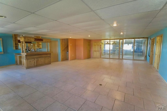 empty room with baseboards and a drop ceiling