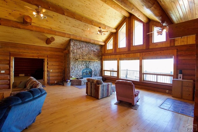 living area with wood ceiling, a fireplace, beam ceiling, high vaulted ceiling, and log walls