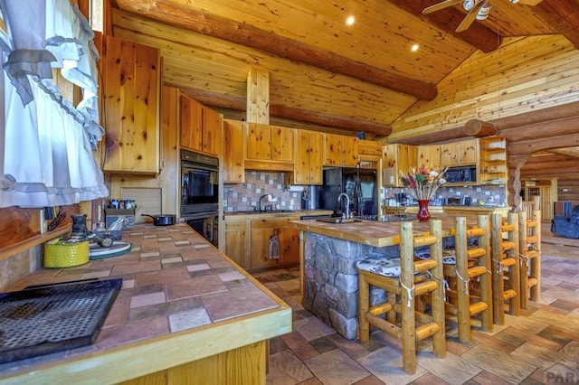 kitchen with a ceiling fan, tasteful backsplash, a sink, lofted ceiling with beams, and black appliances