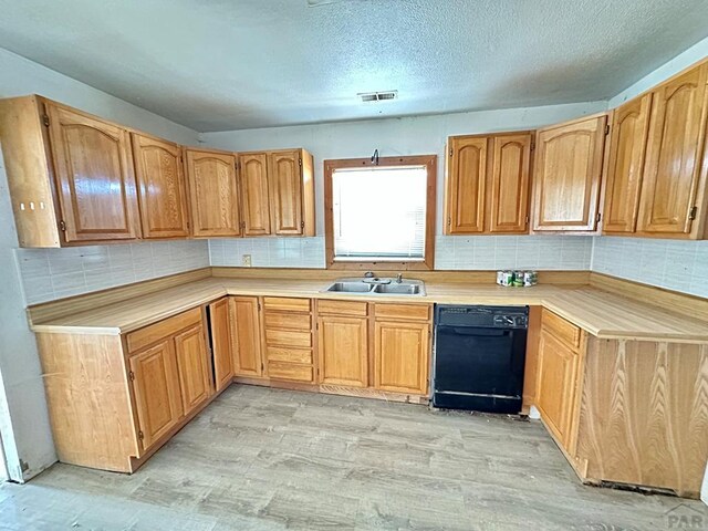 kitchen featuring a sink, visible vents, light countertops, and dishwasher