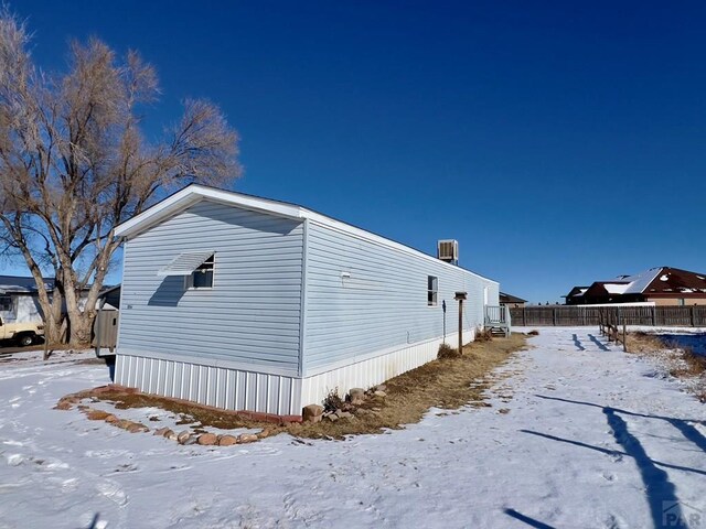 view of snowy exterior featuring fence