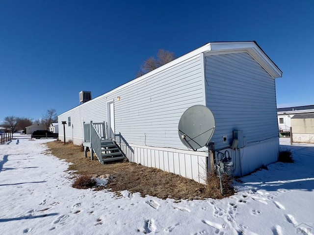 view of snowy exterior with central AC unit