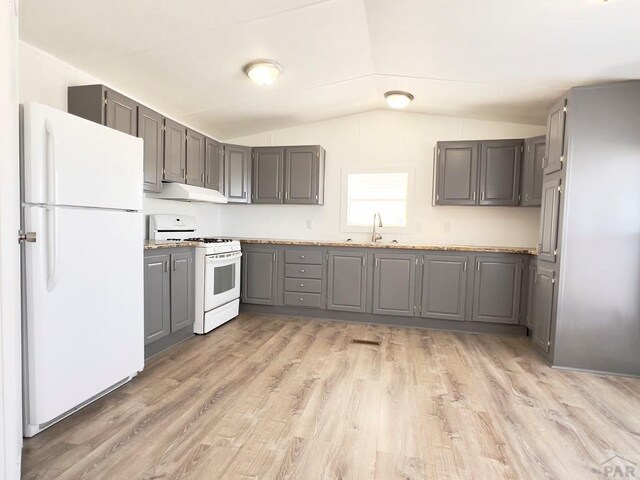 kitchen featuring under cabinet range hood, gray cabinetry, white appliances, vaulted ceiling, and light wood-type flooring