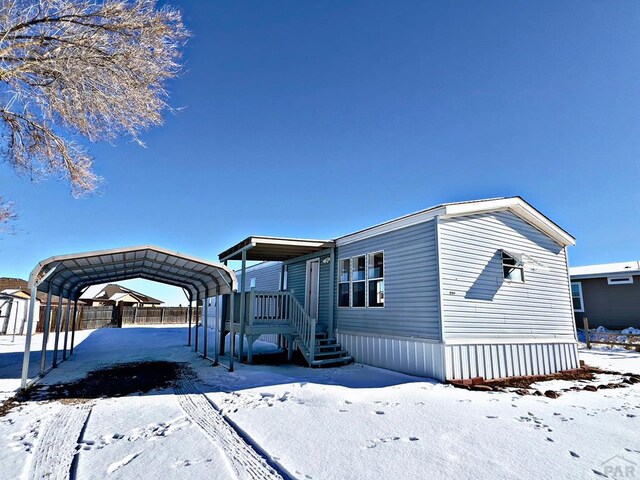 view of front of home with fence and a detached carport