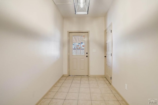 doorway to outside with light tile patterned flooring and baseboards