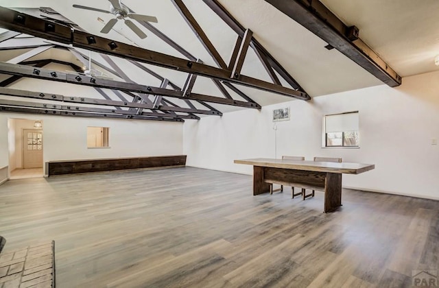 rec room with wood finished floors, a ceiling fan, and vaulted ceiling with beams
