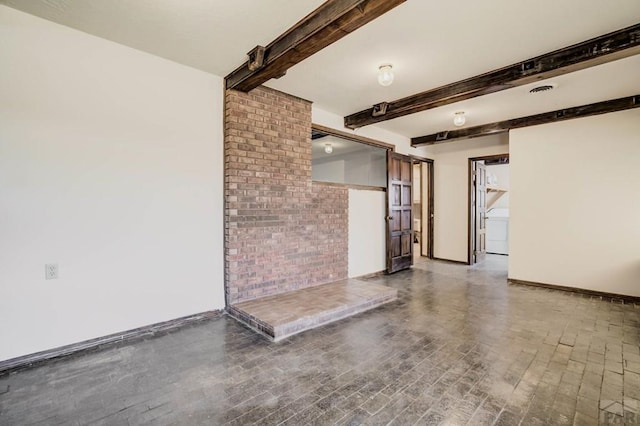 spare room featuring beam ceiling and baseboards