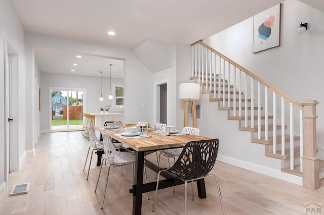 dining space with stairway, visible vents, light wood-style flooring, and baseboards