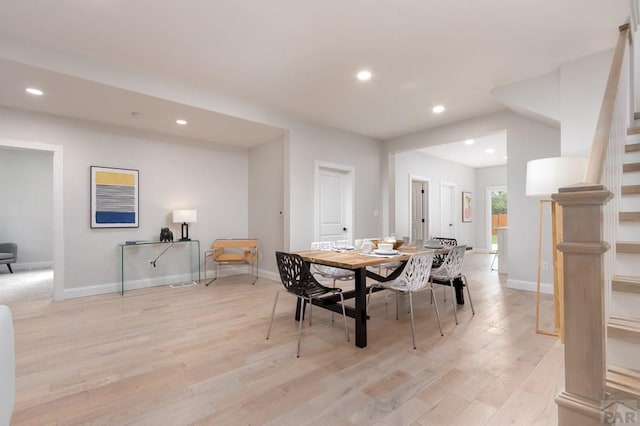 dining room featuring light wood-style flooring, stairs, baseboards, and recessed lighting