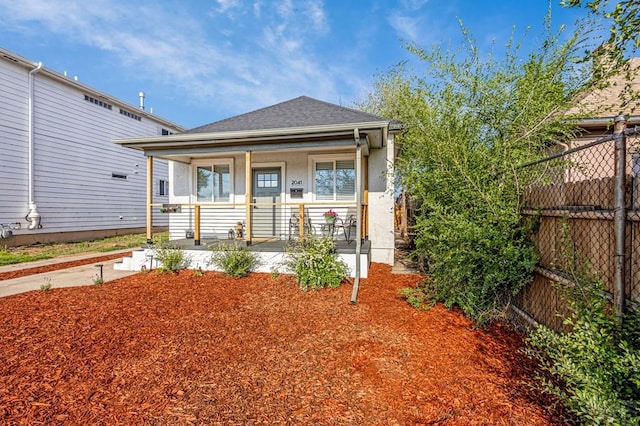 2041 Spruce St, Pueblo, CO 81004 - view of front of property with fence, a porch, stucco siding, and roof with shingles