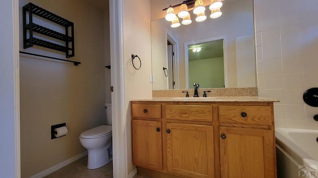 bathroom with washtub / shower combination, vanity, toilet, and baseboards