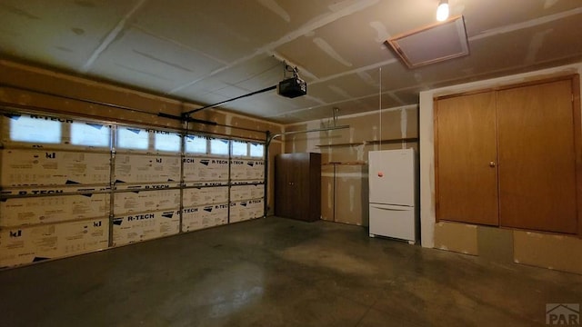 garage with a garage door opener and freestanding refrigerator