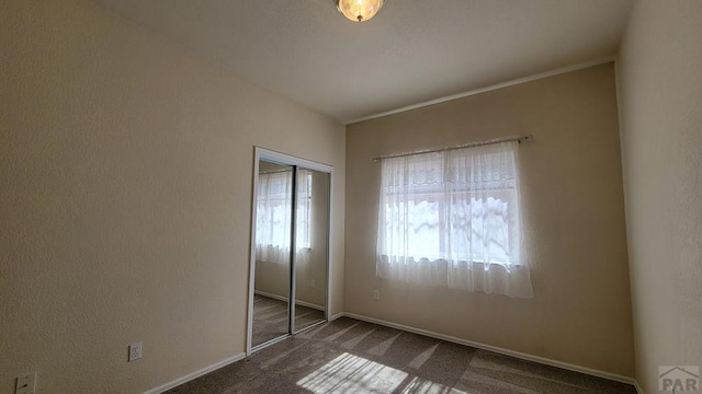 unfurnished bedroom with carpet floors, a closet, and baseboards