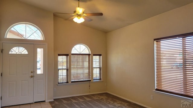 carpeted entryway with lofted ceiling, ceiling fan, and baseboards