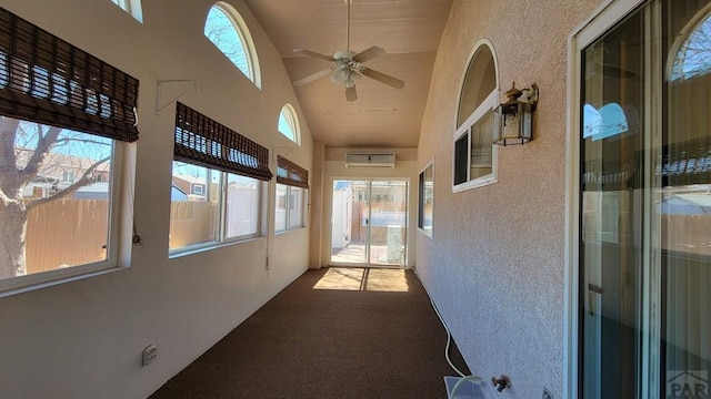 exterior space featuring a wall unit AC and a ceiling fan