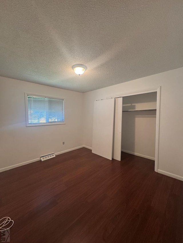 19 Cornell Cir, Pueblo, CO 81005 - unfurnished bedroom with a textured ceiling, dark wood-type flooring, and a closet