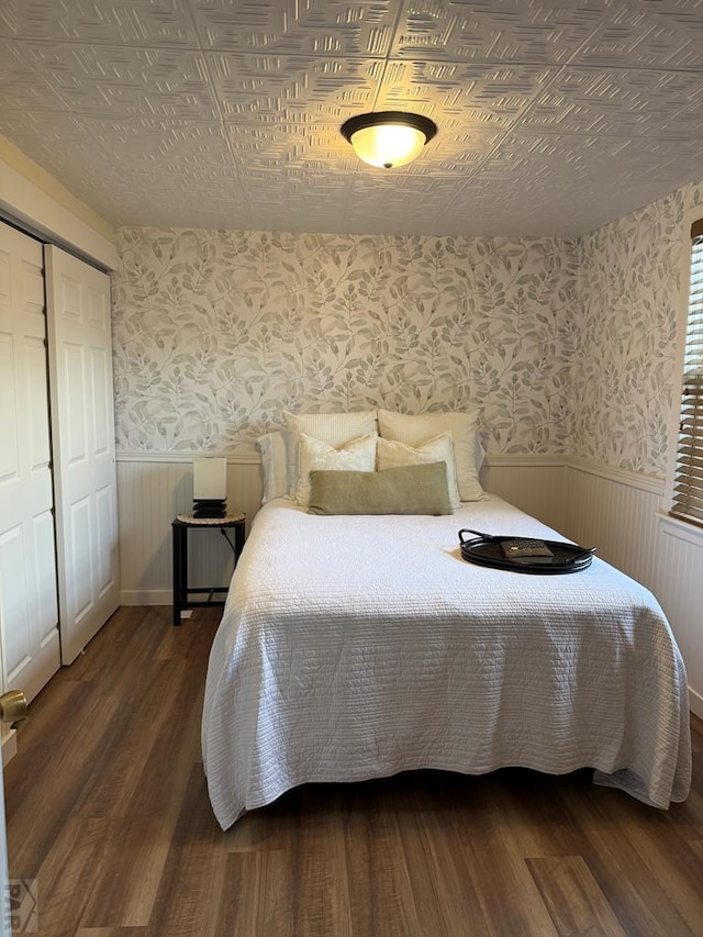 402 Alma Ave, Pueblo, CO 81004 - bedroom featuring wallpapered walls, wainscoting, wood finished floors, an ornate ceiling, and a closet