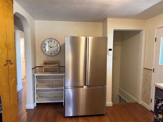 402 Alma Ave, Pueblo, CO 81004 - kitchen with freestanding refrigerator, wood finished floors, arched walkways, and a textured ceiling