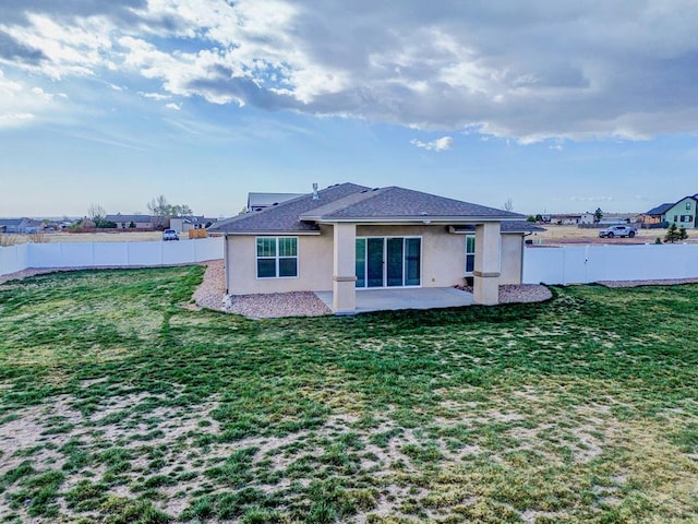 back of property with stucco siding, a fenced backyard, a yard, and a patio area