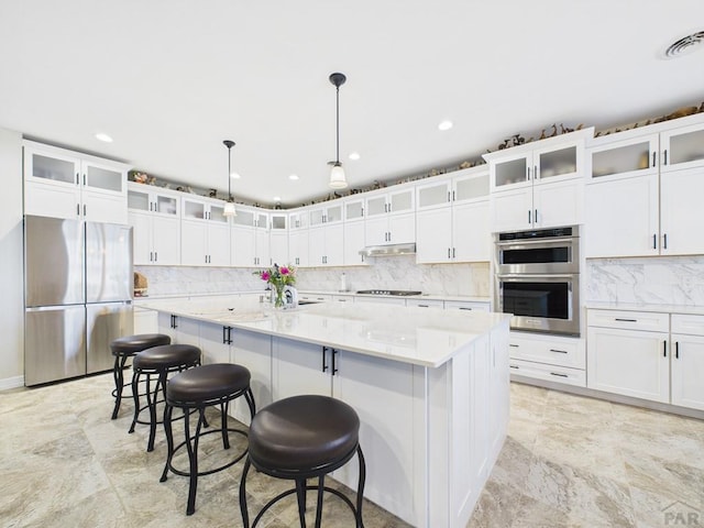 kitchen with white cabinets, a spacious island, backsplash, and stainless steel appliances