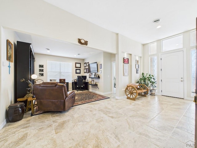 living area with baseboards and visible vents