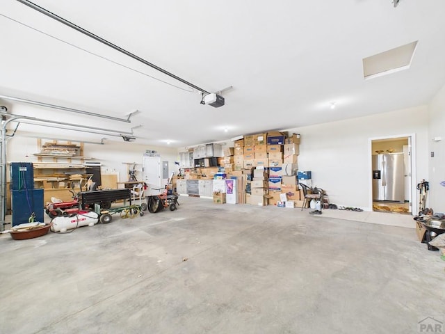 garage featuring a garage door opener and stainless steel fridge