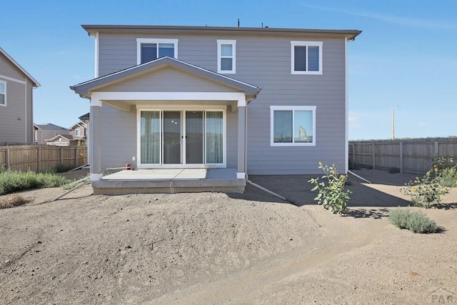 back of property with a patio area and fence