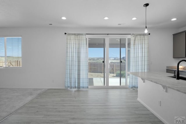 unfurnished living room featuring light wood finished floors, baseboards, and recessed lighting