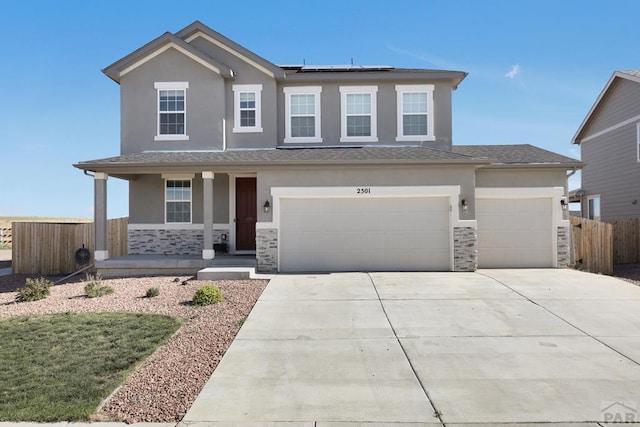 view of front of property featuring stone siding, a porch, stucco siding, and roof mounted solar panels