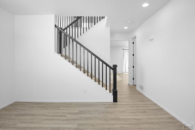 stairs with recessed lighting, visible vents, baseboards, and wood finished floors