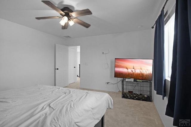 bedroom featuring visible vents, a ceiling fan, and light colored carpet