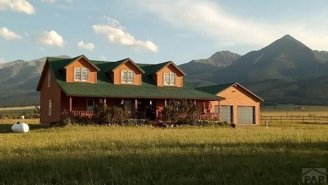 view of front of house with metal roof, an attached garage, and a mountain view